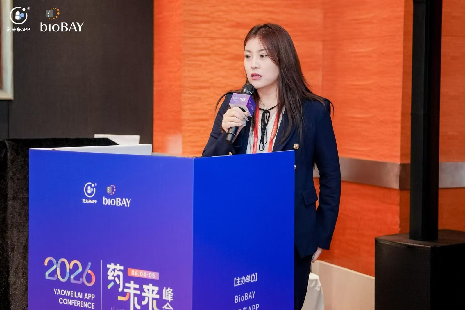Jessica Hu speaking on stage at a biotechnology industry conference